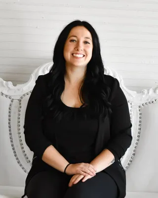 Portrait of Autumn Johnson, seated on a white studded couch