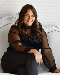 Portrait of Jenna Kirchner, seated on a white studded couch