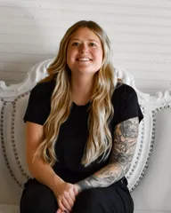 Portrait of Lexi Vaningan, seated on a white studded couch